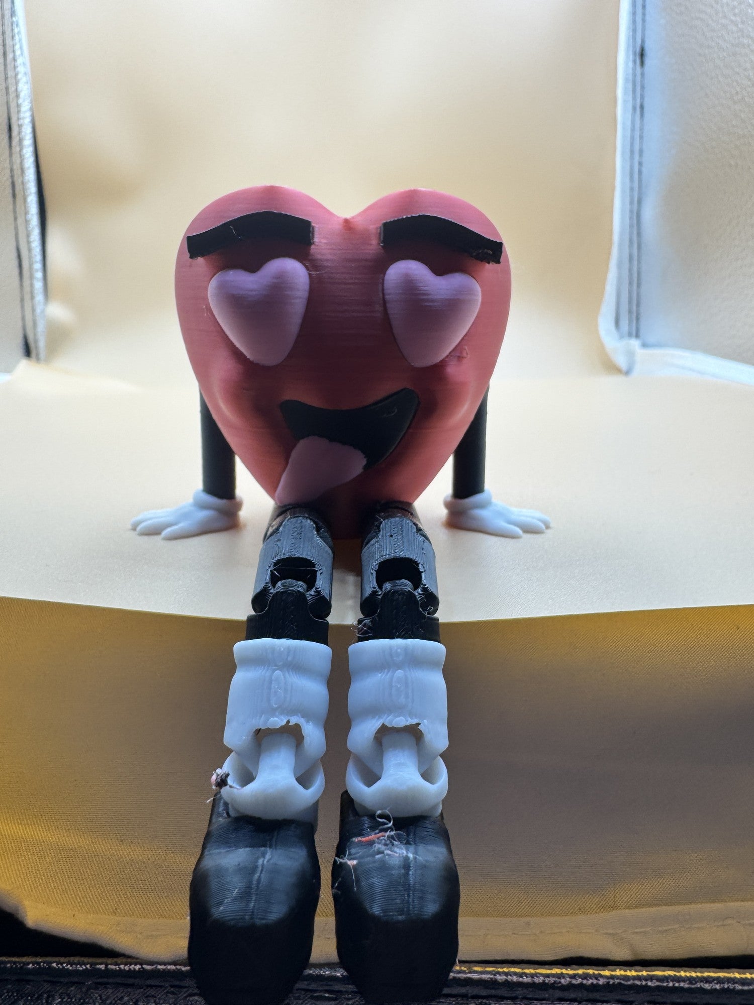 Smitten flexi heart sitting on a monitor with legs hanging over